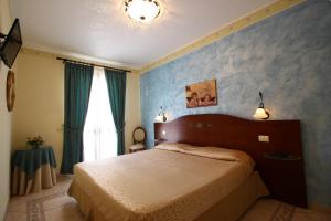 ランペドゥーザにあるGran Residence Marisaの青い壁のベッドルーム1室(ベッド1台付)