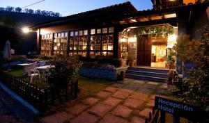 a building with a table in front of it at night at Hotel Mirador de La Franca in La Franca