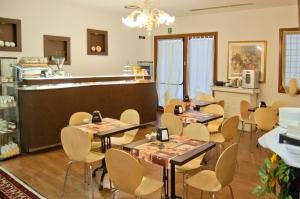 a room with tables and chairs and a kitchen at Hotel Leon Bianco in Adria