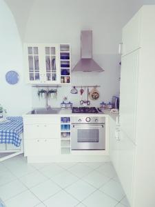 una cucina bianca con piano cottura e lavandino di Casa Giovanna Gioia ad Atrani