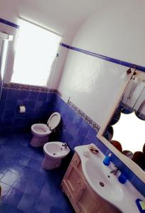 bagno piastrellato blu con servizi igienici e lavandino di Casa Giovanna Gioia ad Atrani
