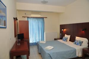um quarto de hotel com duas camas e uma secretária em Ionion Star Hotel em Tholón