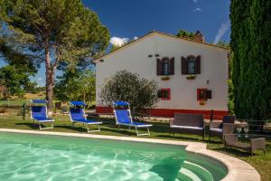 ein Pool mit Stühlen und ein Haus im Hintergrund in der Unterkunft B&B Borgo Vera in Manciano
