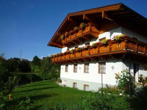 budynek z balkonem pokrytym kwiatami w obiekcie Appartement Bergkristall w mieście Sankt Johann im Pongau