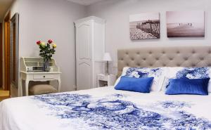 een slaapkamer met een blauw en wit bed met blauwe kussens bij Lora Center Room in Como