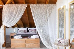 Schlafzimmer mit Himmelbett und Vorhängen in der Unterkunft Archodiko Toliadi Boutique Apartments and Suites in Ouranoupoli