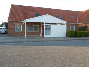 a brick house with a white garage next to a street at Stevnstrup Ferielejlighed in Stevnstrup