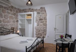 a bedroom with a bed and a table with chairs at Bokun Guesthouse in Dubrovnik