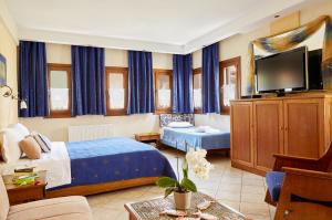 Habitación de hotel con cama y TV en Archodiko Toliadi Boutique Apartments and Suites en Ouranoupoli