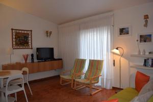 sala de estar con 2 sillas, mesa y TV en Casa da Praia | Luz Beach, en Luz