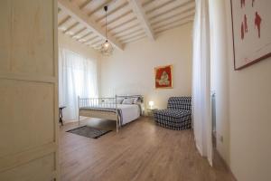 a room with a bed and a chair and a window at B&B In Acquaviva in Livorno