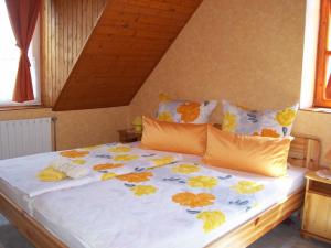 a bed with yellow and orange flowers on it at Haus Martha in Balatonudvari