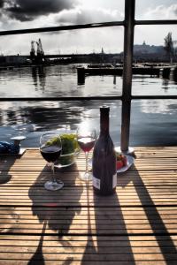 una botella de vino y dos copas en un muelle en Hausboot - Domy na wodzie - Houseboat Porta Mare - Odradream, en Szczecin