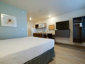 מיטה או מיטות בחדר ב-WoodSpring Suites Broken Arrow