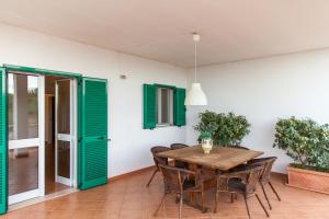 Villa Carenza في مونوبولي: غرفة طعام مع طاولة وكراسي خشبية