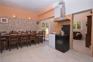 cocina y comedor con mesa y fogones en Villa Ivas, en Milna