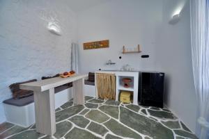a kitchen with a table and a sink in a room at AMO Folegandros in Karavostasi