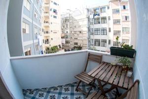 リスボンにあるLuna Apartmentのベンチ付きのバルコニーから建物の景色を望めます。