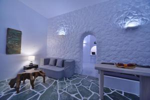 a living room with a blue couch and a table at AMO Folegandros in Karavostasi