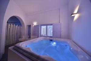 a large blue tub in a room with a window at AMO Folegandros in Karavostasi