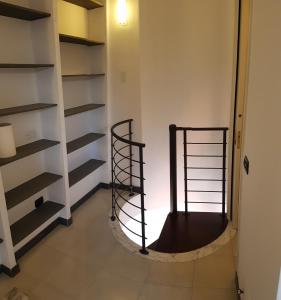 a room with shelves and a spiral staircase at Mansarda Stefania in Ameglia