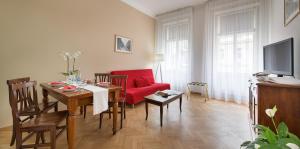 a living room with a table and a red chair at Hotel Suite Home Prague in Prague