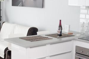 a white kitchen with a counter with a wine glass on it at Apartament Garazowa 5 in Warsaw