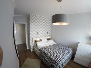 sypialnia z łóżkiem z czarno-białą kołdrą w obiekcie Apartament Garazowa 5 w Warszawie
