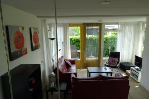 a living room with a couch and a table at vakantiehuisgalamadammen met ligplaats boot in Koudum