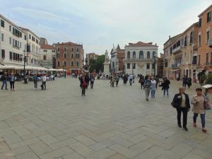 un grupo de personas caminando por una calle de la ciudad en Ca' Sansovino, en Venecia