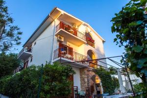 um grande edifício branco com varandas vermelhas e árvores em Villa Veca em Starigrad-Paklenica