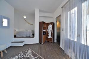 a room with a bedroom with a bed and a closet at AMO Folegandros in Karavostasi