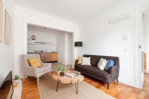 ein Wohnzimmer mit einem Sofa und einem Tisch in der Unterkunft Casa Santa Marinha in Lissabon