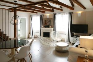 a living room with a table and chairs and a television at Bellavista Attic Apartment in Izola