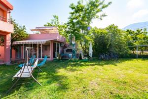 a house with a yard with chairs and a swing at Apartments Vanja in Bar