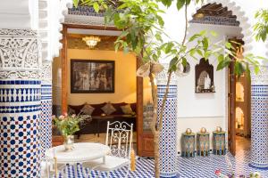 un soggiorno con tavolo e piastrelle bianche e blu di Astra Damus Hotel a Marrakech