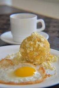 MC Suites Boutique في غواياكيل: بيضة مقلية على صحن مع كوب من القهوة