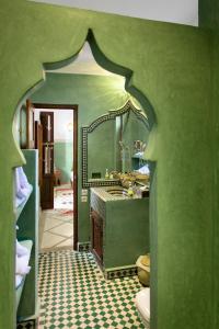 un bagno verde con lavandino e specchio di Astra Damus Hotel a Marrakech Altre 37 foto