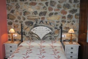 una camera con un letto con due comodini e due lampade di Mirador De Urriellu a Poo de Cabrales