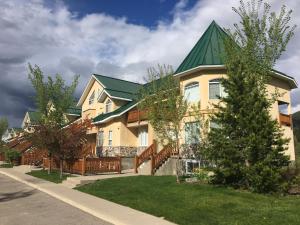 a large house with a green roof at Riverside by FantasticStay in Fernie
