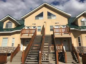 a large house with stairs leading up to it at Riverside by FantasticStay in Fernie