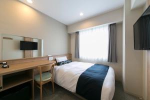 Tempat tidur dalam kamar di Just Inn Premium Nagoya Station