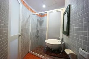 a bathroom with a shower and a white sink at A Cup Hostel in Kenting
