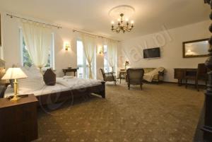 a bedroom with a large bed and a living room at Rewa in Rewal
