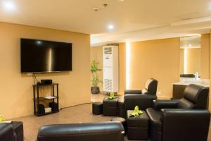 a living room with couches and a flat screen tv at Boracay Haven Suites in Boracay