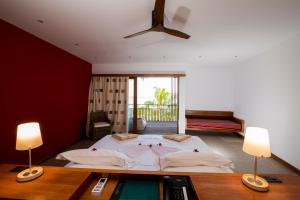 Hanimaadhoo的住宿－赤腳生態酒店，一间卧室配有一张大床和两盏灯