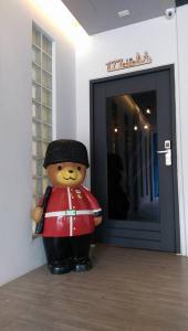 un oso de peluche en uniforme parado frente a una puerta en 177 Guest House, en Nantou City