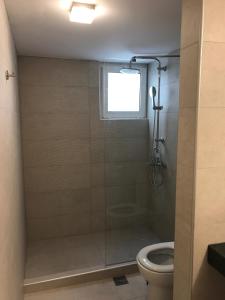 a bathroom with a shower with a toilet and a window at Neapolis Apartments in Palaiochora