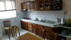 a kitchen with a sink and wooden cabinets at Residence Lasenza Apartment in Flic-en-Flac