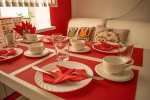 ヤクーツクにあるGostinitsa "Landysh"の赤いテーブルクロスに皿とカップをかけたテーブル